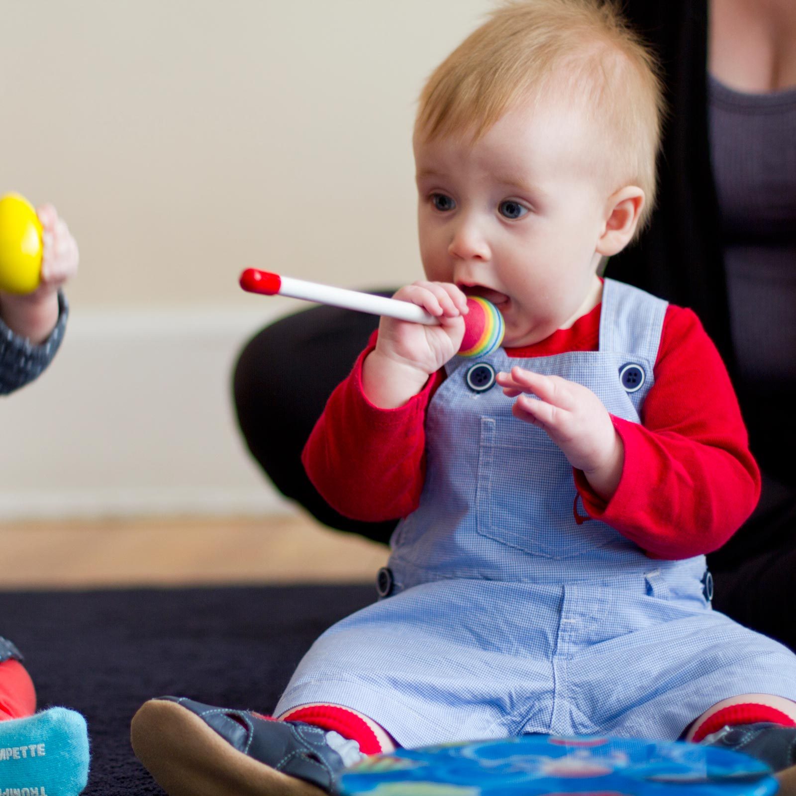 Two older babies holding musical toys in a Baby Movement class in NYC